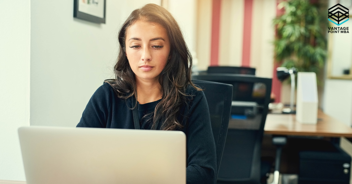 Young woman at her computer deciding if she wants to push her MBA applications to Round 2