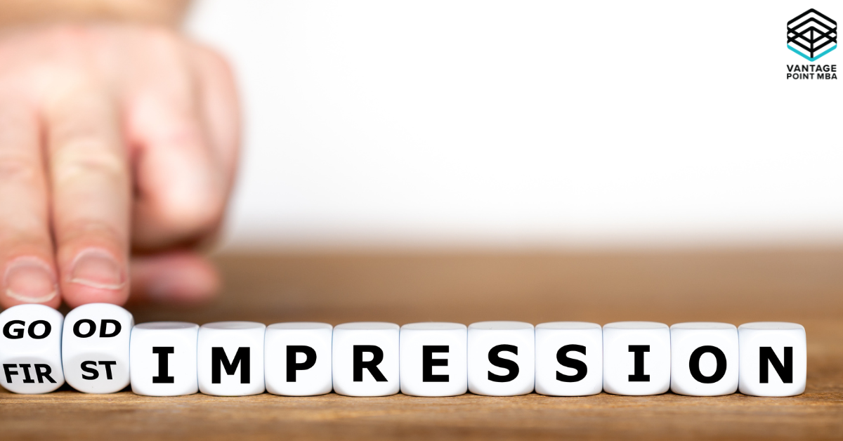 A close-up of a hand pushing dice blocks on a wooden surface. The dice spell out "GOOD FIRST IMPRESSION," with "GOOD" and "FIRST" split across smaller dice blocks, while "IMPRESSION" is spelled out in large, bold black letters on white dice blocks.