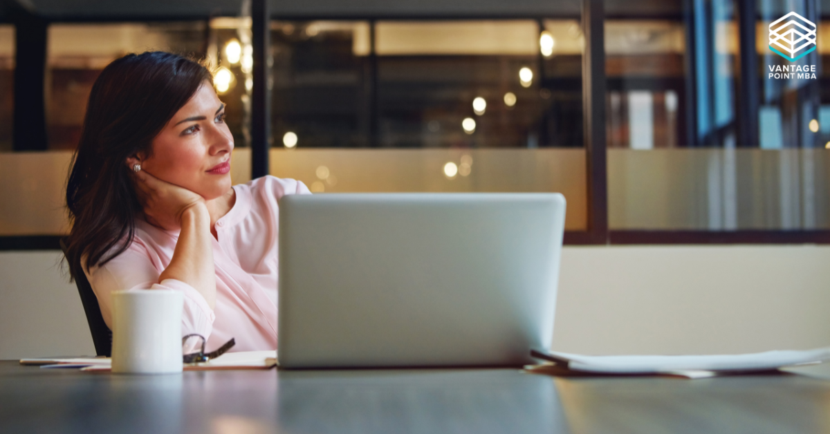 Business woman at her laptop, contemplating a job change while she applied to business school