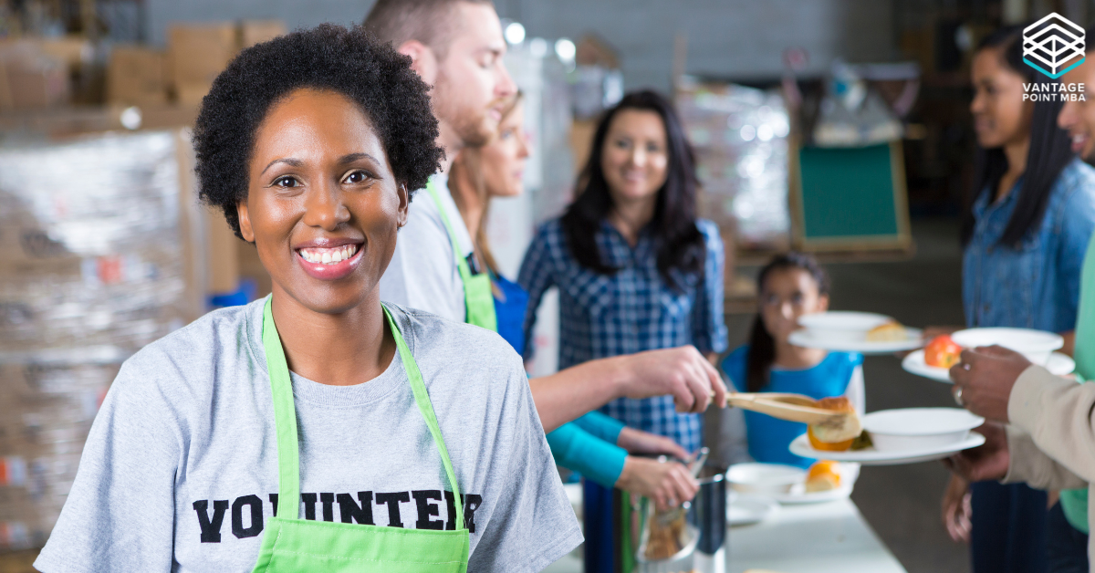 Woman engaging in community service, highlighting how extracurriculars can demonstrate leadership for MBA applications. Vantage Point MBA logo in corner.
